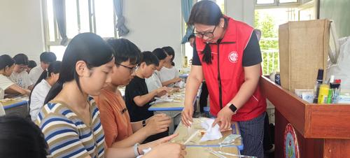 4鄭州藝術(shù)幼兒師范學(xué)校教師趙晨和學(xué)生一同展示扎染成果